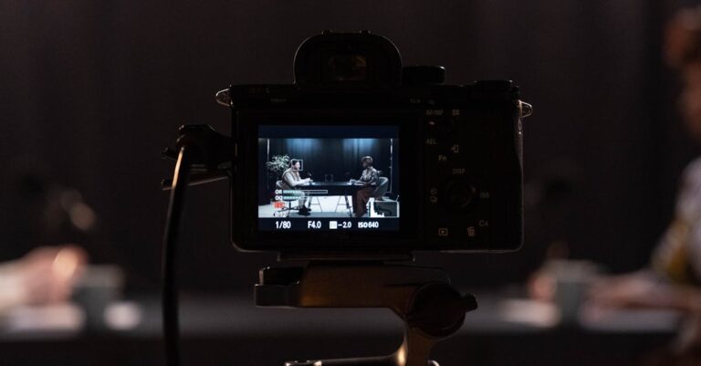 Close-up of a camera recording a podcast interview in a studio setting.
